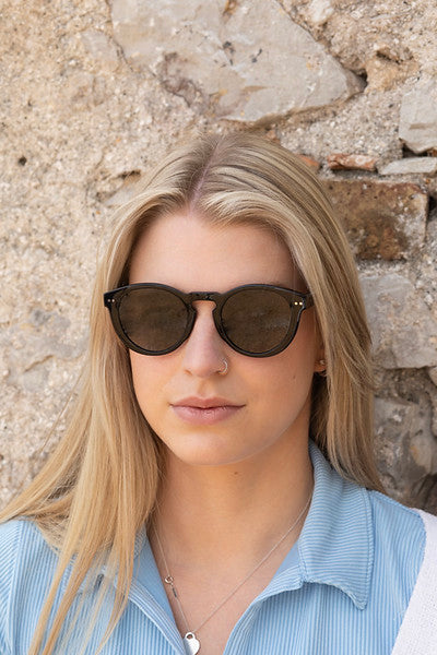 Woman wearing Savona sunglasses with black frame and green lenses