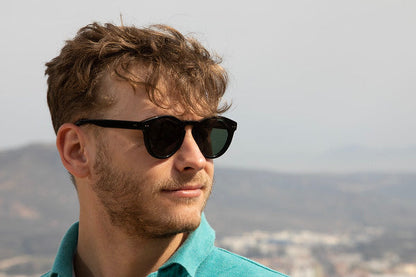 Man wearing Savona sunglasses with black frame and green lenses